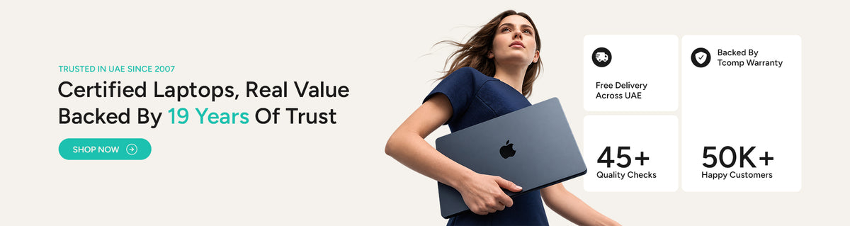 A woman in a navy blue top holds a silver laptop while standing in a bright, modern office setting. The left side features promotional text for certified laptops and trust badges on the right.
